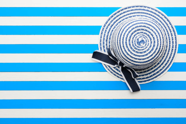 Striped hat in blue and white background. Top view, flat lay. - Photo, Image