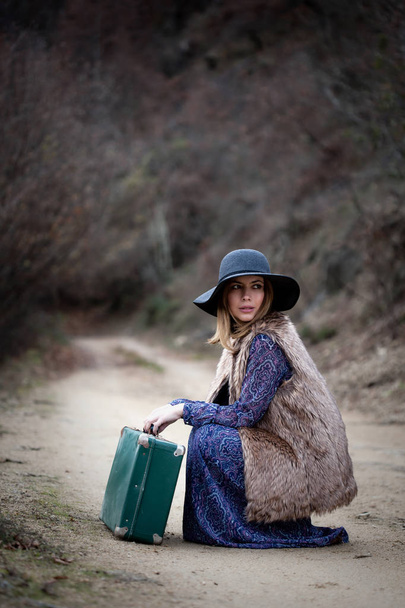 pretty girl with vintage case on a dirtroad - 写真・画像