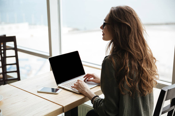 Back view of woman with blank screen of laptop - Φωτογραφία, εικόνα