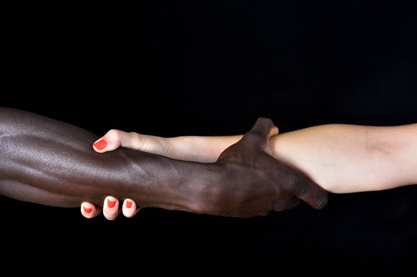 Руки чорного чоловіка і білої жінки на чорному тлі
 - Фото, зображення