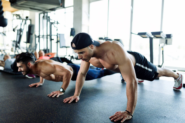 men doing push-ups in gym - Фото, изображение
