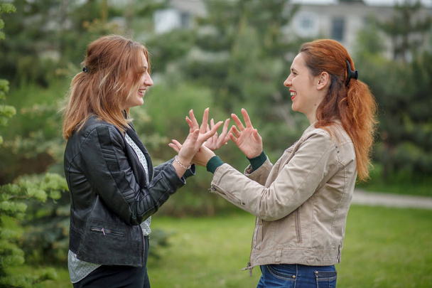 γυναίκες που έχουν πρόσωπο με πρόσωπο συνομιλία χειρονομώ με τα χέρια - Φωτογραφία, εικόνα
