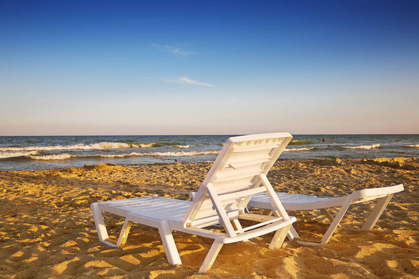 Two deckchairs on the sandy beach - Fotó, kép