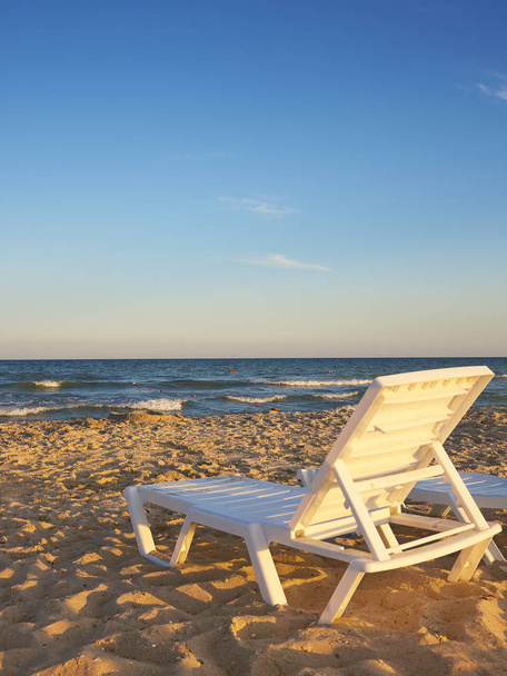 Deckchairs on the beach with bright sun and waves - Zdjęcie, obraz