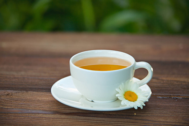 xícara de porcelana com chá verde na mesa
 - Foto, Imagem