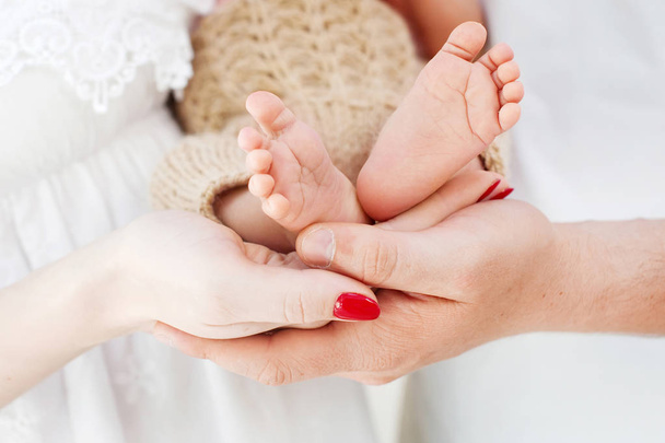Baby feet in parents hands. Tiny Newborn Baby's feet on parents  - 写真・画像