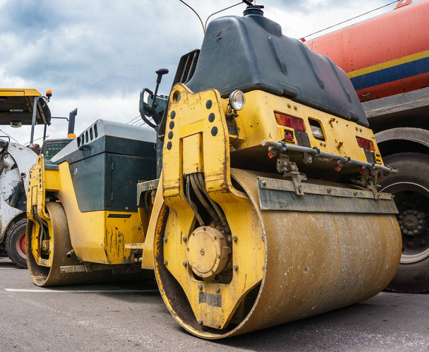 Sárga építési traktor úthenger és technikával aszfalt megállapításáról - Fotó, kép