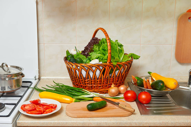 kitchen interior with vegetables and fresh greens in basket, healthy food concept, top view - Φωτογραφία, εικόνα