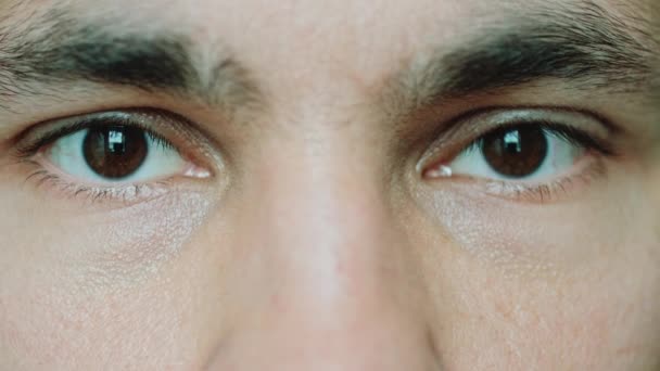 Bruine ogen mannen kijken naar de camera - Video