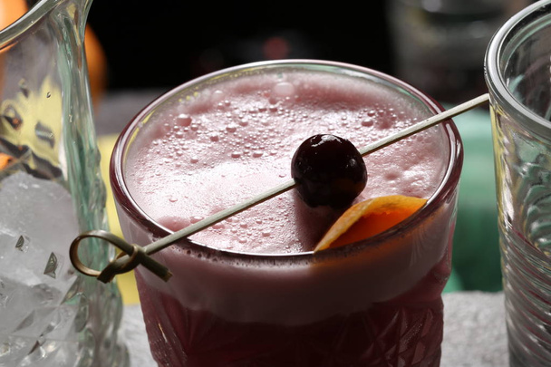 Cherry cocktail on a skewer and with thick foam. Close up - 写真・画像
