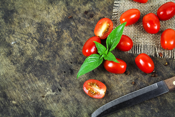 Wiśniowe pomidory z bazylią liść na białym tle - Zdjęcie, obraz