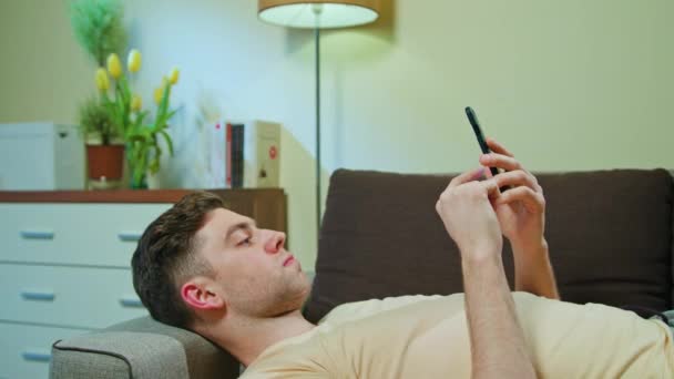 Mann liegt auf dem Sofa und benutzt Handy - Filmmaterial, Video