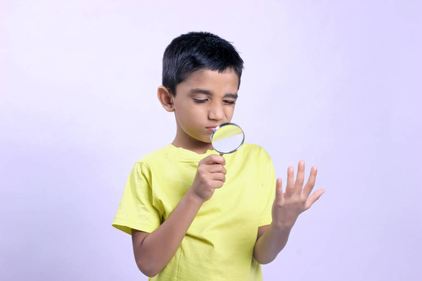 little indian boy holding magnifying glass  - Valokuva, kuva