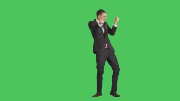 Longue prise de vue d'un bel homme d'affaires souriant dansant, faisant geste de pistolets à doigts et s'amusant. Le fond est l'écran vert
. - Séquence, vidéo