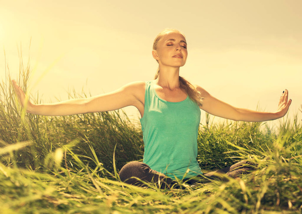  Blonde junge Frau meditiert mit geschlossenen Augen in der Natur - Foto, Bild
