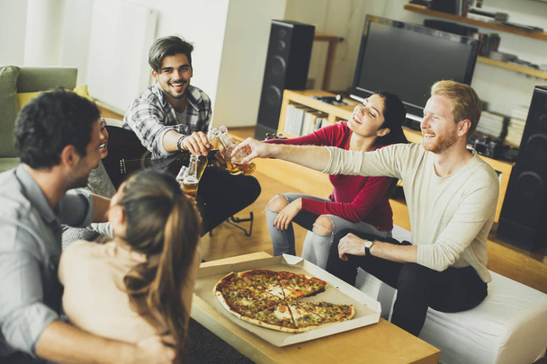 Nuoret syövät pizzaa ja juovat siideriä
 - Valokuva, kuva