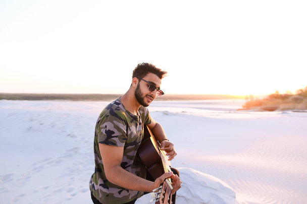 Portré, közeli portré Arab srác, aki játszik a gitár strin - Fotó, kép
