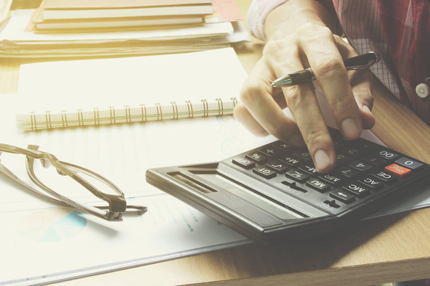 Hand rekenmachine op de office desk investeringen en de eigenschap gebruiken  - Foto, afbeelding
