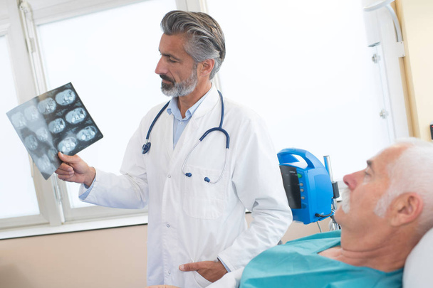 Doctor showing xrays to patient - Valokuva, kuva