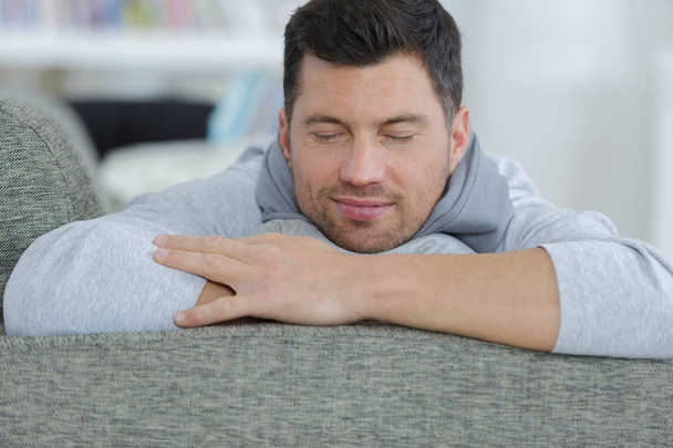 casual happy man relaxing on couch in bright living room - Photo, image