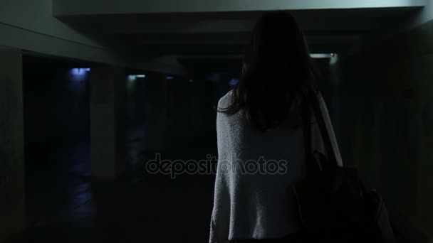 Przerażona kobieta działa przez ciemny tunel - Materiał filmowy, wideo