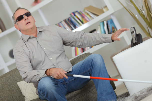 Blind and deaf man using stick at home - Zdjęcie, obraz