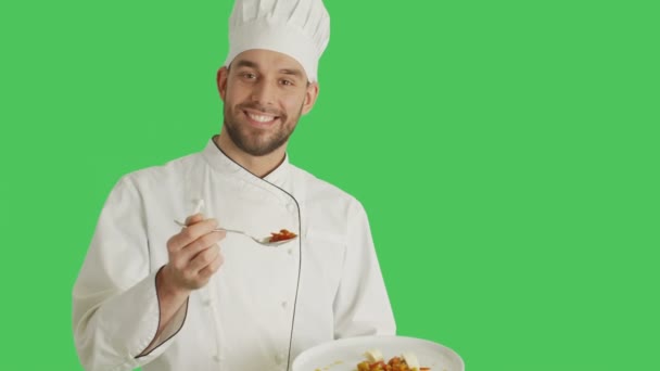 Mid Shot of a Handsome Chef Holding Plate With Dish Decorating Dish with a Spoon. Shot with Green Screen Background. - Materiał filmowy, wideo