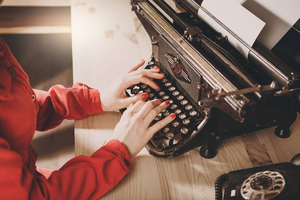 Sekretärin an alter Schreibmaschine mit Telefon. junge Frau mit ty - Foto, Bild