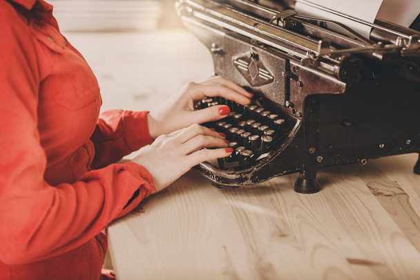 Секретарь старой пишущей машинки с телефоном. Молодая женщина с помощью ти
 - Фото, изображение