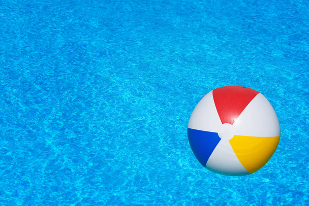 Разноцветный надувной шар, плавающий в бассейне - Фото, изображение