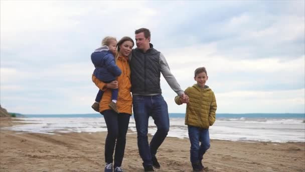 Genitori felici e due bambini che camminano sulla costa
 - Filmati, video