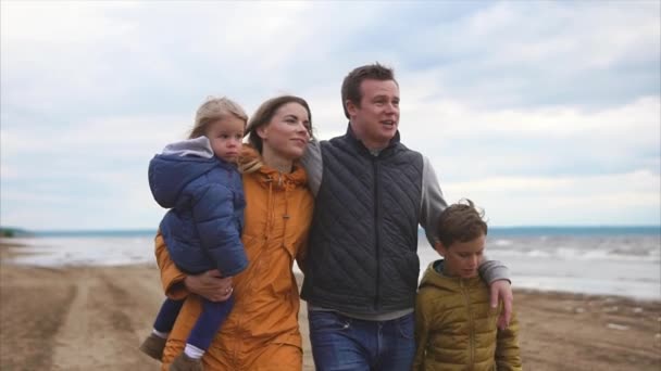 Ευτυχισμένοι και φιλικό οικογένεια είναι το περπάτημα με τα παιδιά τους στην παραλία στα ρεπό - Πλάνα, βίντεο