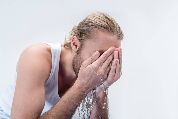 młody człowiek mycia twarzy  - Zdjęcie, obraz