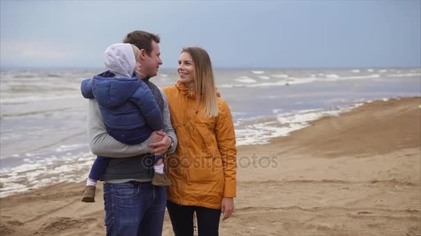 Женатая пара с ребенком стоит на пляже и наслаждается выходными
 - Кадры, видео
