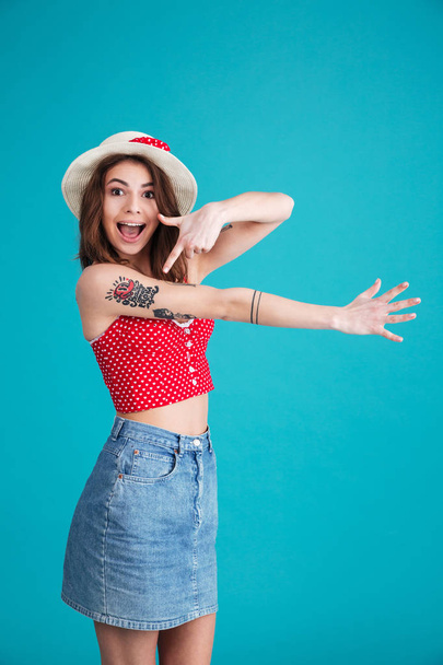 Happy young lady standing and pointing to her tattoo. - Foto, imagen