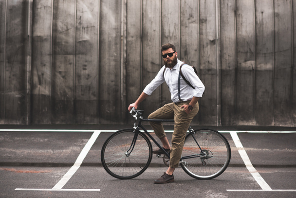 stylish man sitting on bicycle - Foto, afbeelding