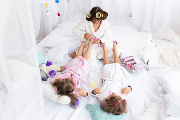 Mujer y niños en la cama
 - Foto, Imagen