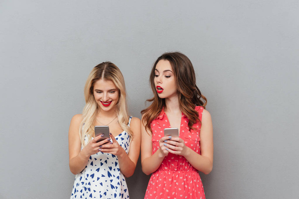 Happy young ladies chatting by phone. - Foto, Imagen