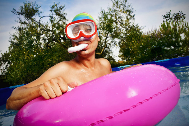 man in een draagbare zwembad zwemmen - Foto, afbeelding