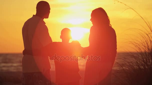 οικογένεια απολαμβάνοντας την Ανατολή του ηλίου στην παραλία  - Πλάνα, βίντεο