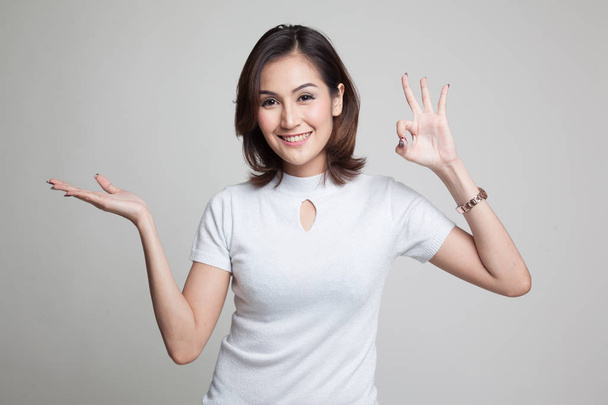 Beautiful young Asian woman show palm hand and OK sign. - Photo, image