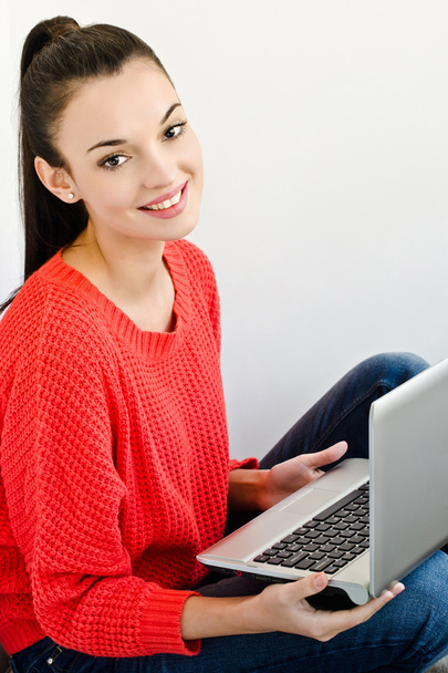 Beautiful smiling girl holding a laptop. - Foto, afbeelding