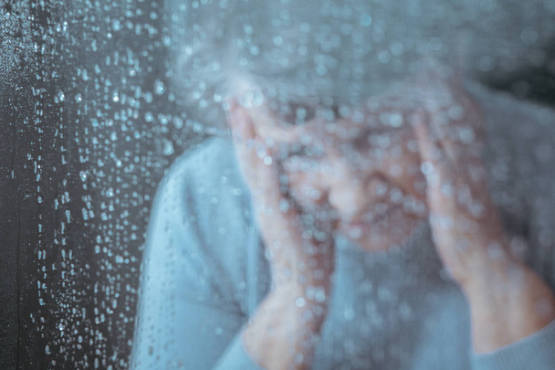 Sad woman behind the glass - Фото, зображення