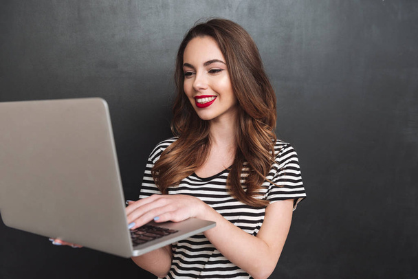 Smiling woman using laptop computer - Фото, изображение