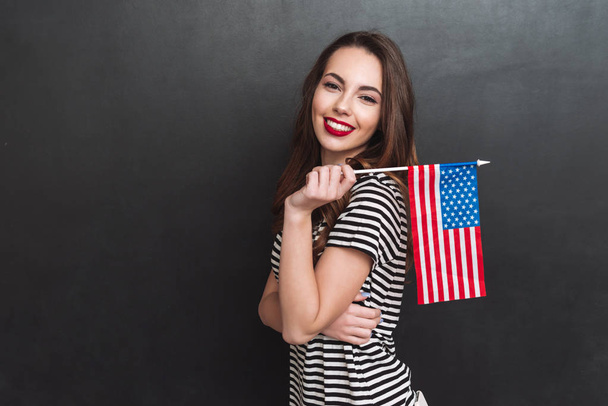 Side view of woman holding USA flag - Fotó, kép