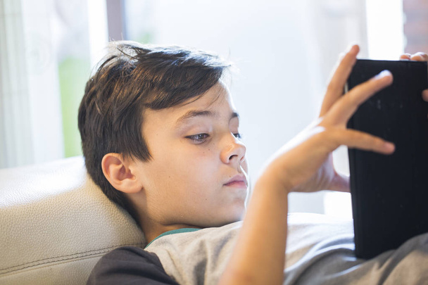 jongen met zijn tablet spelen - Foto, afbeelding
