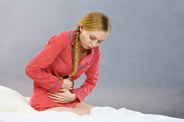 Sad young teenager woman on bed feeling pain - Valokuva, kuva