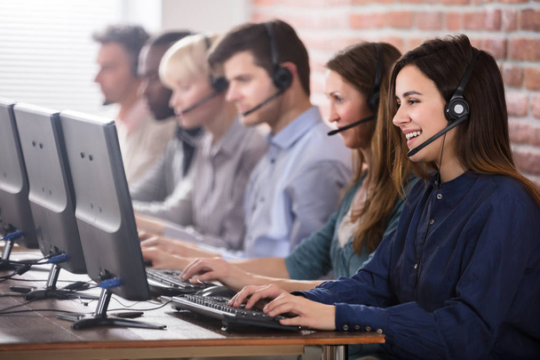 Positive Female Customer Services Agent With Headset Working In A Call Center - Фото, изображение