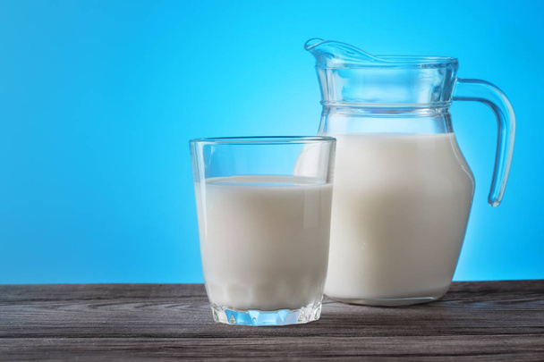 Кувшин и стакан с молоком на деревянном столе
 - Фото, изображение