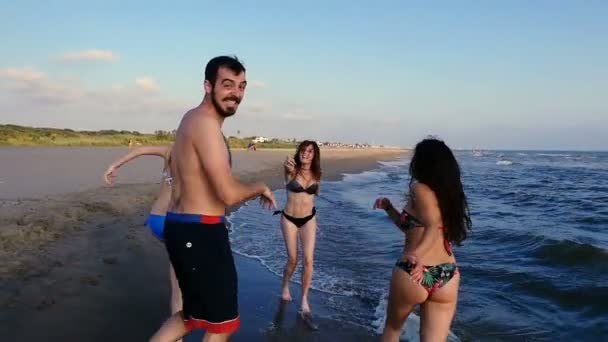 Câmera seguindo amigos felizes correndo na praia na hora de verão
 - Filmagem, Vídeo